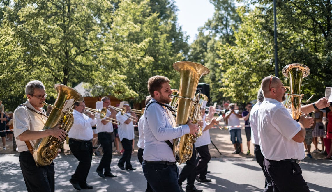 A lively marching band performs on the streets of Poděbrady, Czechia, showcasing brass instruments.