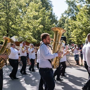 A lively marching band performs on the streets of Poděbrady, Czechia, showcasing brass instruments.